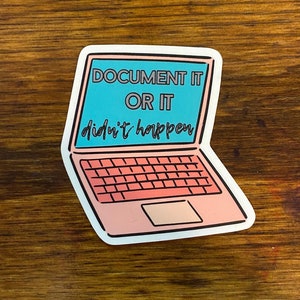May include: A pink laptop sticker with the text "DOCUMENT IT OR IT didn't happen" in black and white text on a blue background.