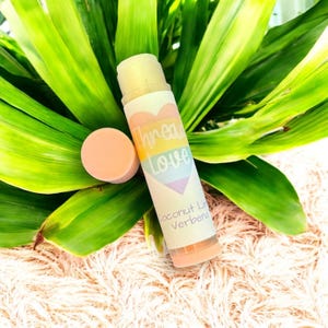 May include: A pink lip balm tube with a rainbow heart and the text "Spread Love" on the label. The label also says "Coconut Lime Verbena".