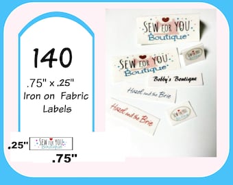 Peut inclure: Plusieurs étiquettes en tissu thermocollantes. Les étiquettes rectangulaires affichent les textes "SEW FOR YOU Boutique", "Bobby's Boutique" et "Hazel and the Brie". L'image affiche également un graphique avec les dimensions 1,9 cm x 0,6 cm.