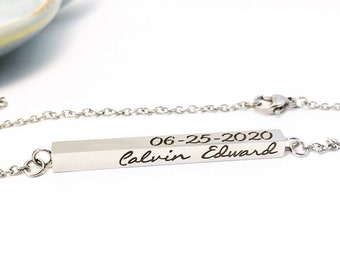 May include: A silver necklace with a bar pendant engraved with the date "06-25-2020" and the name "Calvin Edward" in cursive.