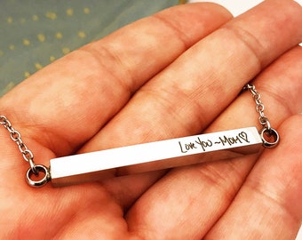 May include: A silver bar necklace with a chain and a personalized inscription that reads "Love you - Mom" with a heart symbol.