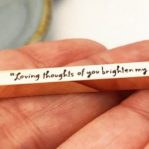 May include: Gold bar necklace with the inscription "Loving thoughts of you brighten my days."