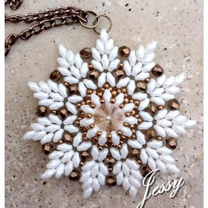 May include: A white and bronze beaded snowflake pendant necklace. The snowflake is made with small white beads and bronze beads in a geometric pattern. The necklace has a bronze chain.