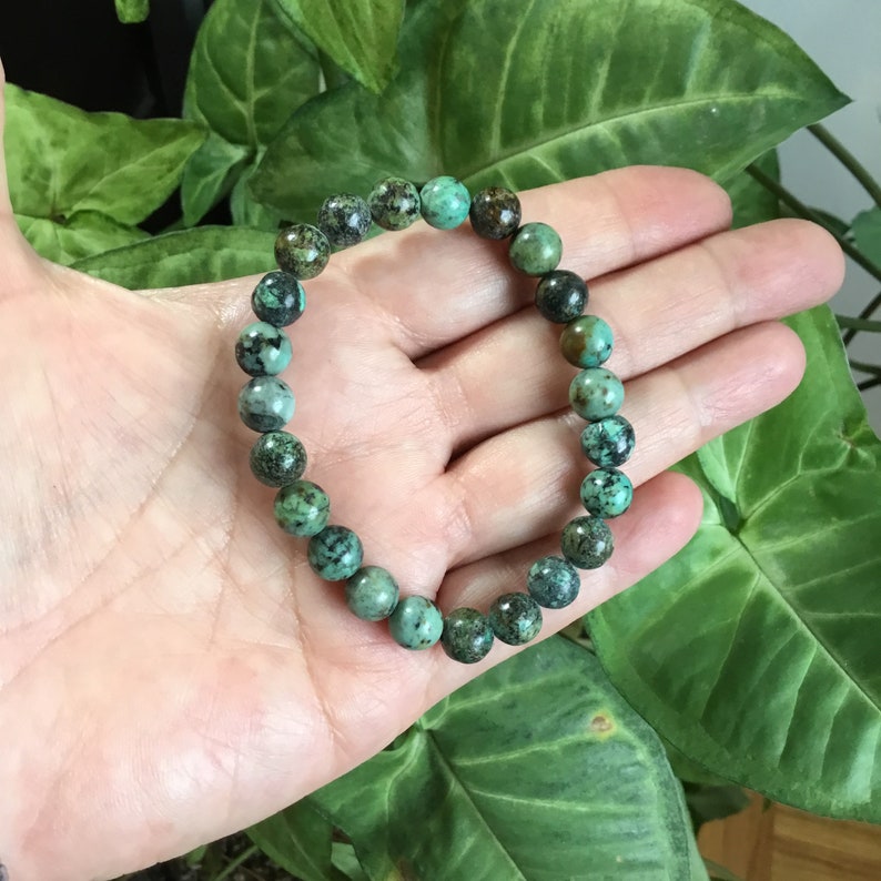 May include: A turquoise gemstone bracelet with round beads. The bracelet is made of natural stones and has a rustic look.