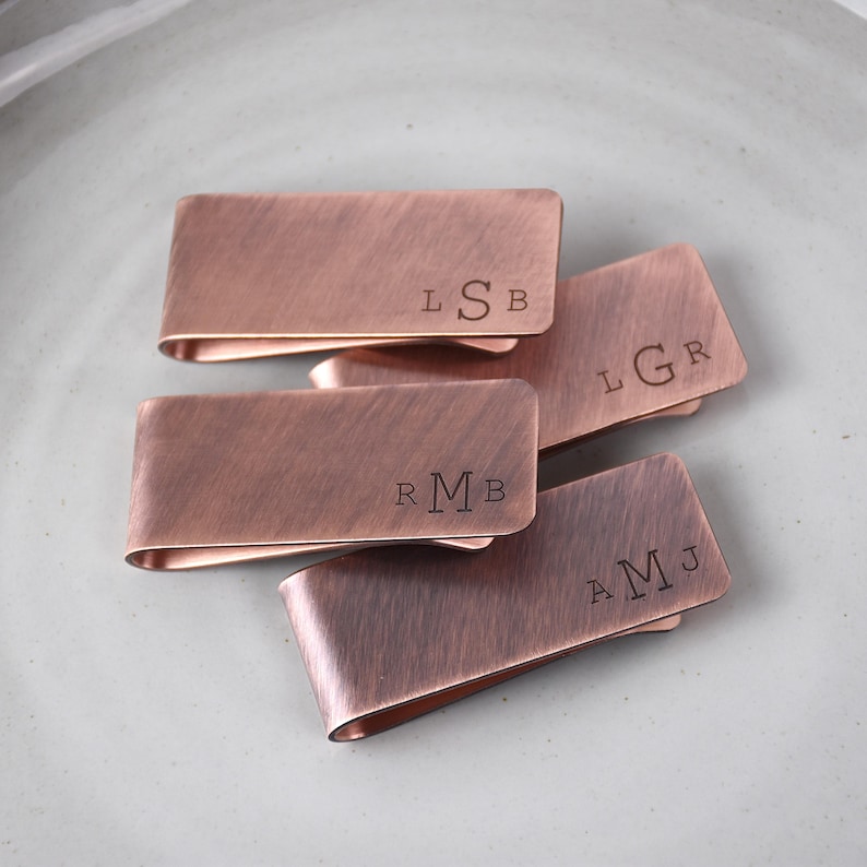 Set of 4 personalized copper money clips with monogrammed initials in antique font.