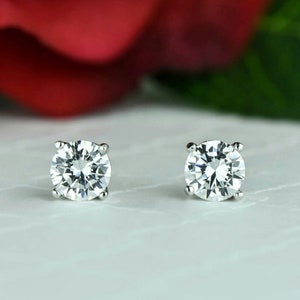 May include: A pair of silver stud earrings with clear round cubic zirconia stones.
