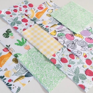 May include: Nine fabric squares with different patterns, including strawberries, lemons, plants, and vegetables. The squares are arranged in a grid pattern.