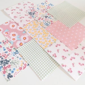 Könnte beinhalten: Sortiment aus acht Stoffquadraten mit verschiedenen Blumenmustern. Die Quadrate sind in den Farben Rosa, Weiß, Gelb und Grün.