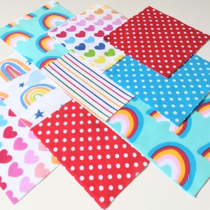 May include: Nine fabric squares with different patterns, including rainbows, hearts, polka dots, and stripes. The squares are arranged in a grid pattern.