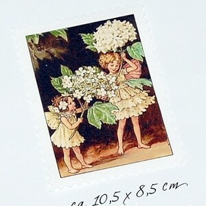 Puede incluir: Imagen rectangular de estilo vintage con dos niños con alas de hadas sosteniendo grandes flores blancas. La imagen tiene un fondo oscuro y mide aproximadamente 10,5 x 8,5 cm. La imagen está sobre un fondo blanco con un borde decorativo.