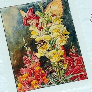 Op de afbeelding: Een vintage illustratie van een fee met een vlindervleugel, genesteld tussen gele en rode leeuwenbekken. Het kunstwerk staat op een rechthoekige kaart, ongeveer 10,5 cm bij 8,0 cm. De fee draagt een rode hoed en is omringd door bloemen.