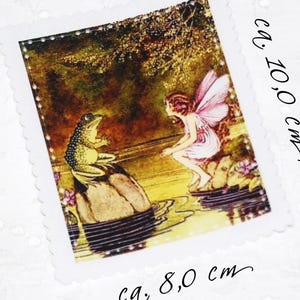 May include: A vintage-style illustration of a fairy with pink wings sitting on a rock in a pond, talking to a green frog on a rock. The image is printed on a fabric square with a white border and measures approximately 8 cm by 10 cm.