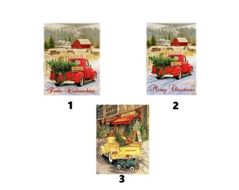 May include: Three rectangular decorative signs featuring vintage trucks. Two signs show a red truck with a Christmas tree in a snowy farm setting with the text Frohe Weihnachten and Merry Christmas. One sign shows a yellow truck in a city.