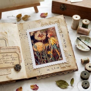 May include: An open scrapbook with a vintage aesthetic, featuring a postage stamp-like image of a person in a yellow jacket among dandelions. The stamp is approximately 3 x 4 inches. The page is adorned with lace, dried petals, and sewing supplies.