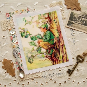 Könnte beinhalten: Eine Vintage-Postkarte mit einer Fee in grüner Kleidung, die in einem Baum sitzt, mit einem Schlüssel, einem kleinen Löffel und einer Postkarte eines Pavillons. Die Feenkarte misst ca. 7,0 cm x 10,0 cm.