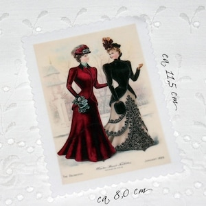 Könnte beinhalten: Vintage-Illustration von zwei Frauen in modischen Kleidern aus dem Januar 1899. Die Frauen tragen Hüte und stehen in einer verschneiten Umgebung. Die Illustration ist auf einer Karte mit einem gewellten Rand gedruckt. Die Karte misst etwa 8,0 cm mal 11,5 cm.