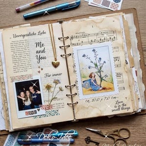 Könnte beinhalten: Ein offenes Ringbuch mit gealterten Papierseiten, einer goldenen Herzanhänger-Halskette, einem Polaroid-Foto von drei Personen, einer Feen-Illustration, Notenblättern und Texten wie "Unvergessliche Liebe," "Me and You" und "Love is in the small things."