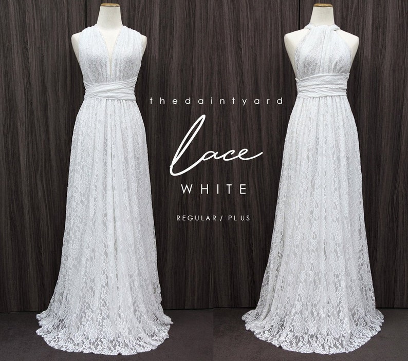 Pu&ograve; includere: Abito maxi in pizzo bianco con scollo halter e corpetto avvolgente. L'abito &egrave; mostrato su un manichino su uno sfondo di legno. Il testo "the dainty yard lace WHITE REGULAR/PLUS" &egrave; visibile nell'immagine.