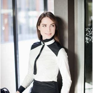Geometrisk svartvit blus: Mandarinkrage, Swarovski-detalj