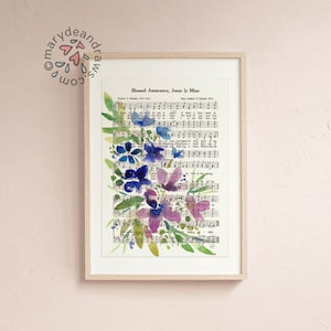 May include: A framed print of a watercolour painting of purple and blue flowers on a vintage sheet music background. The sheet music features the hymn "Blessed Assurance, Jesus Is Mine".