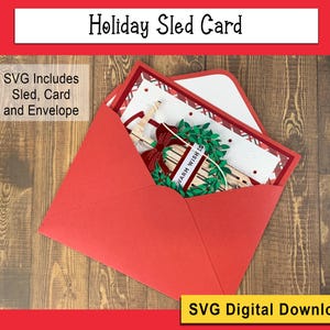 May include: A red envelope with a white card inside. The card features a festive holiday scene with a sled, a wreath, and the text "Warm Wish Is".