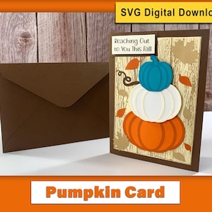 May include: A brown envelope and a fall-themed card with a pumpkin design. The card features three stacked pumpkins in teal, white, and orange, with the text "Reaching Out to You This Fall". The words "Pumpkin Card" are also visible.