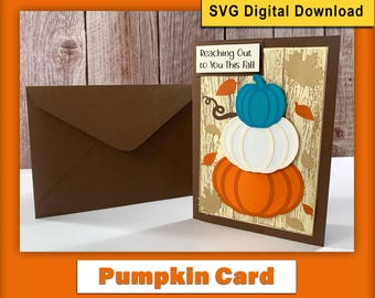 May include: A brown envelope and a fall-themed card with a pumpkin design. The card features three stacked pumpkins in teal, white, and orange, with the text "Reaching Out to You This Fall". The words "Pumpkin Card" are also visible.