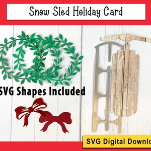 May include: A digital download of SVG shapes for a snow sled holiday card. The image shows a white wooden sled with a green wreath and two red bows.