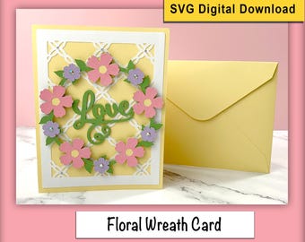 Può includere: Un biglietto giallo con una cornice bianca e una ghirlanda di fiori rosa e viola. La ghirlanda circonda la parola "Love" in scrittura verde. Il biglietto è accompagnato da una busta gialla.