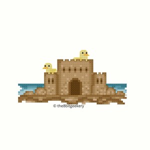 May include: A pixelated illustration of a brown sandcastle with two yellow birds on top. The sandcastle is on a beach with blue water.
