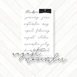 Pode incluir: Uma folha de adesivos preto e branco com os nomes dos meses do ano escritos em letra cursiva. As palavras "Monthly Scripts 02" e "The Blaq Label" estão impressas no topo da folha.