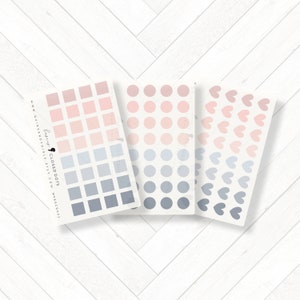 Puede incluir: Tres hojas de pegatinas con diferentes diseños. La primera hoja tiene un degradado de cuadrados rosas y azules. La segunda hoja tiene un degradado de círculos rosas y azules. La tercera hoja tiene un degradado de corazones rosas y azules.