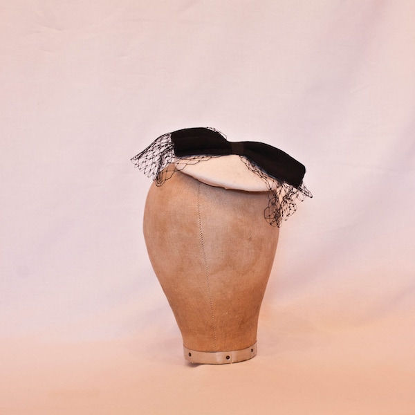 Handmade small cream fascinator with black suede and tulle bow decoration.