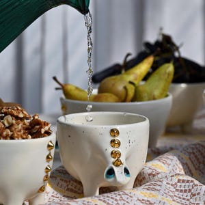 Tazza artigianale con dinosauro, sole e punte dorate.