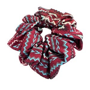 May include: A burgundy scrunchie with a geometric pattern in shades of blue, white, and gray.