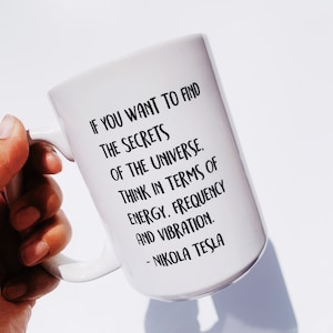 May include: White ceramic mug with a black quote from Nikola Tesla: "If you want to find the secrets of the universe, think in terms of energy, frequency and vibration."