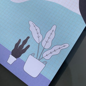 May include: A blue and purple notepad with a grid pattern and a white illustration of a potted plant with three leaves. The plant is in a white pot with a black outline. There is a smaller black plant in a white pot to the left of the larger plant.