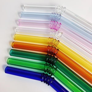 Puede incluir: Un juego de diez pajitas para beber de vidrio de colores con un dise&ntilde;o texturizado y retorcido. Las pajitas est&aacute;n dispuestas en un patr&oacute;n de arco&iacute;ris, comenzando con transparente y terminando con azul.