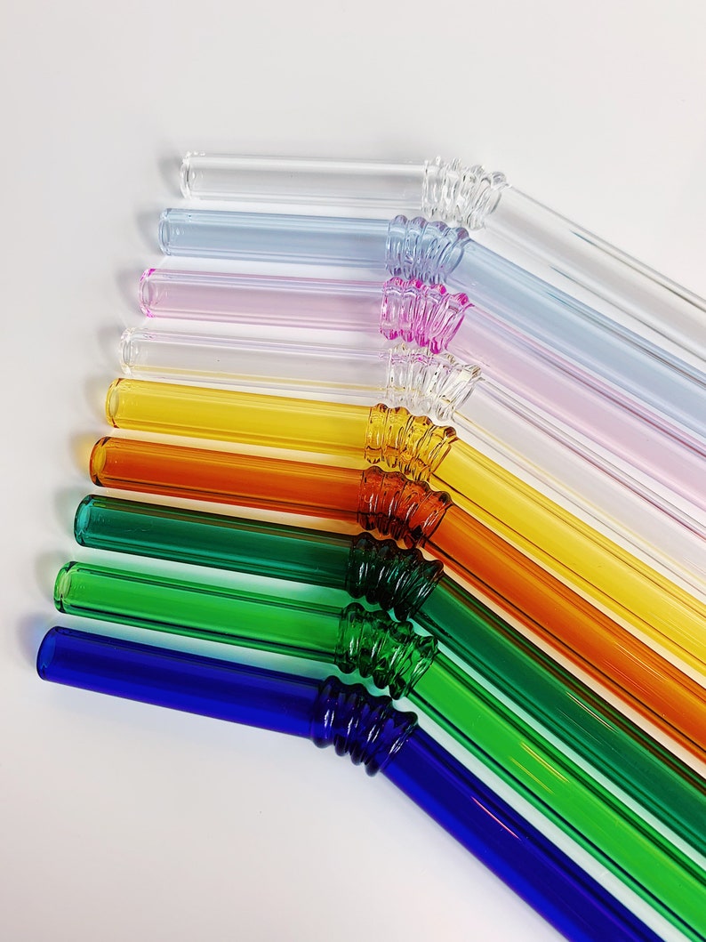 Puede incluir: Un juego de diez pajitas para beber de vidrio de colores con un dise&ntilde;o texturizado y retorcido. Las pajitas est&aacute;n dispuestas en un patr&oacute;n de arco&iacute;ris, comenzando con transparente y terminando con azul.