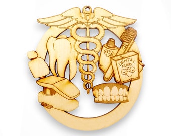 May include: A wooden ornament shaped like a circle with a dental theme. It features a tooth, a dental chair, a toothbrush, toothpaste, dental floss, and a medical symbol with a snake wrapped around a staff. The text "Dental Floss Waxed" is visible on the floss box.