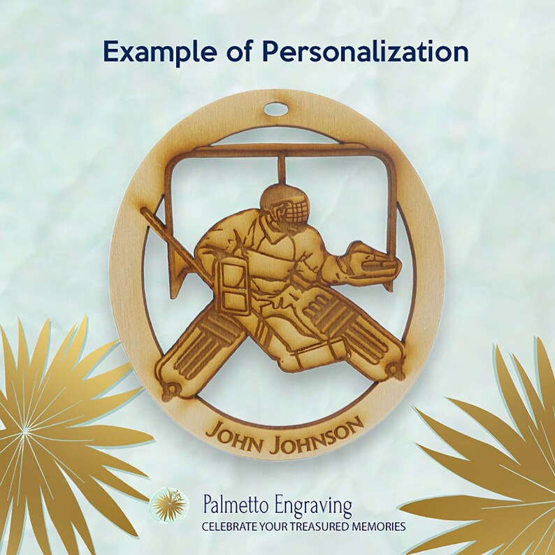 May include: A wooden hockey goalie ornament with a personalized name "John Johnson" on the bottom. The ornament features a detailed silhouette of a hockey goalie in action, with a net behind them. The ornament is a light brown color and has a rustic, handcrafted look.