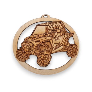 May include: A wooden ornament shaped like a circle with a cutout of a brown and black off-road vehicle. The vehicle has a roll cage and is on large tires.