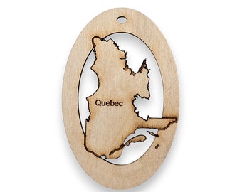 May include: A wooden ornament shaped like the province of Quebec, Canada. The ornament is light brown and has a hole at the top for hanging. The word "Quebec" is written in the center of the ornament.