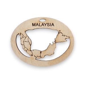 May include: A wooden cutout of the map of Malaysia, with the country name "MALAYSIA" inscribed at the top. The cutout is in the shape of a circle and has a light brown color.