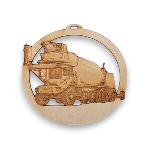 May include: A wooden ornament shaped like a circle with a cutout design of a concrete mixer truck. The truck is brown and has a white cab. The ornament is perfect for construction workers or anyone who loves trucks.