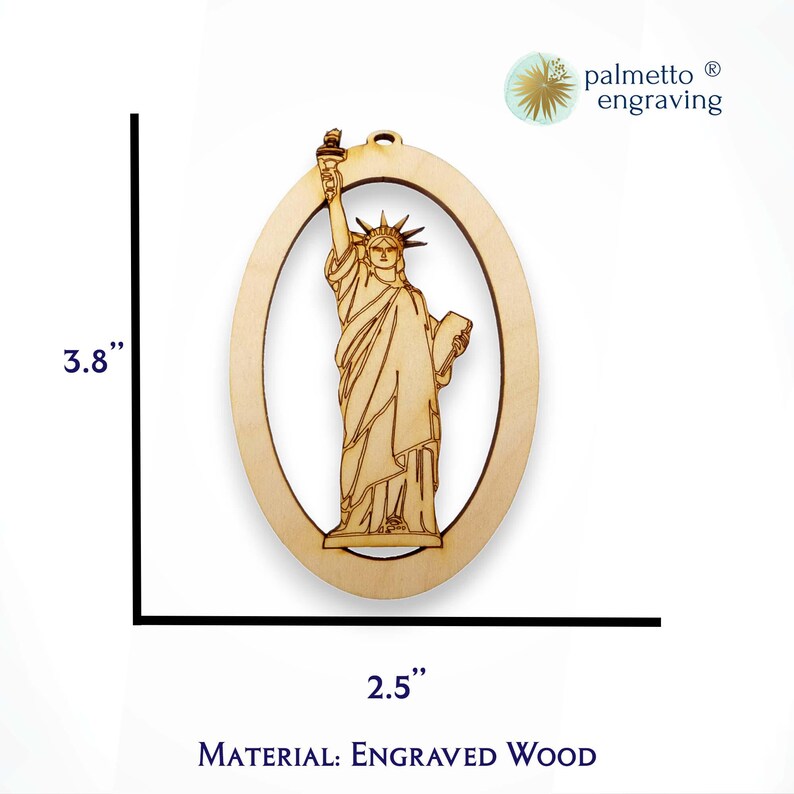 May include: A wooden ornament featuring a detailed engraving of the Statue of Liberty. The ornament is 3.8 inches tall and 2.5 inches wide. It is made of engraved wood.