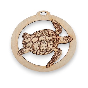 May include: A wooden ornament shaped like a circle with a cutout of a sea turtle. The turtle is brown and has a detailed shell.