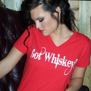 Peut inclure: Un t-shirt rouge à col en V avec le texte "Got Whiskey?" en blanc. Le t-shirt est fait d'une matière douce et convient aux tenues décontractées. Le t-shirt est de couleur rouge uni.