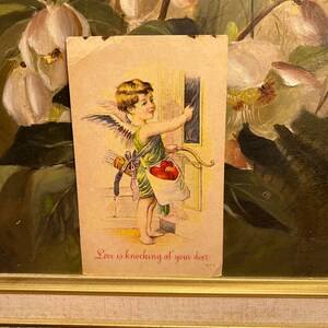 L'amore bussa alla tua porta Cupido con arco e frecce bussa alla porta Cartolina di San Valentino vintage divisa