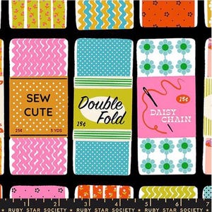 May include: A black fabric featuring a repeating pattern of rectangular sewing trim cards. The cards display various colourful designs, including polka dots, wavy lines, and floral motifs, with text labels such as Sew Cute, Double Fold, and Daisy Chain.